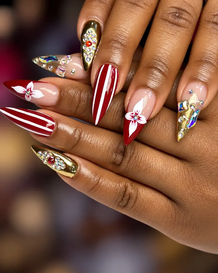 Red stiletto nails with white flowers, stripes and gold chrome gems
