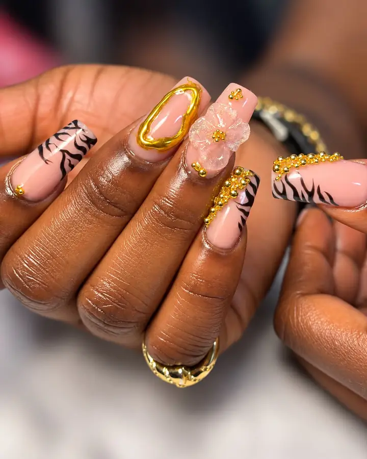 Zebra stripe nails with gold beads, a gold frame and a 3D flower