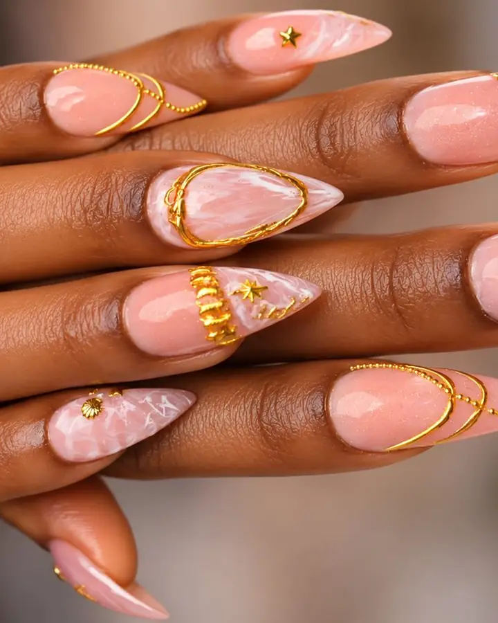 Pink milky stiletto nails with gold stars and gold chain details